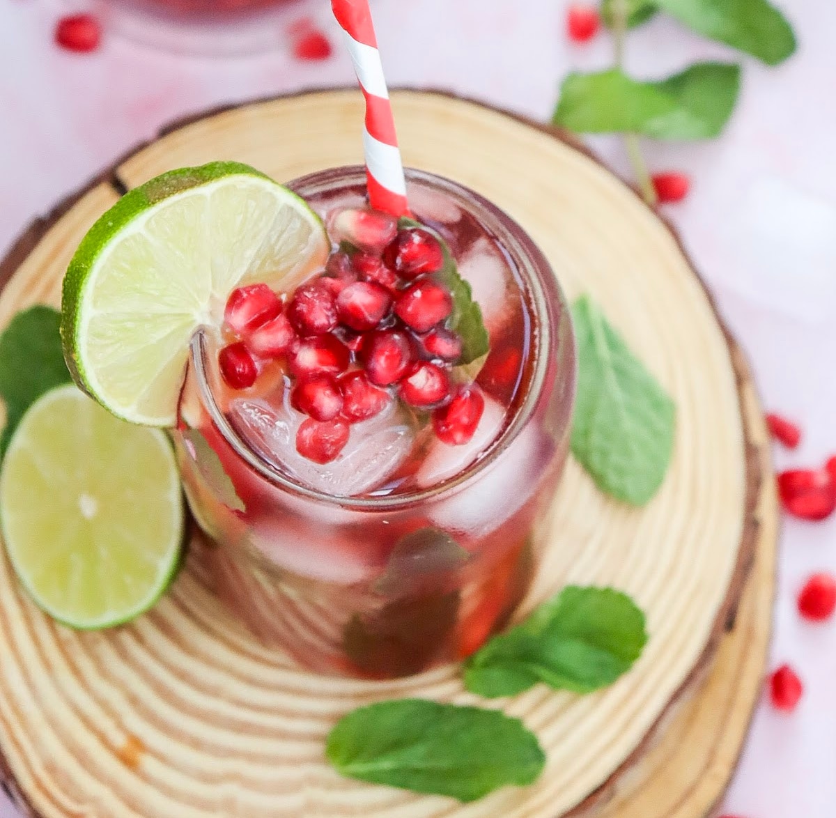 overhead of a mocktail drink with pomegranate seeds and lime slices