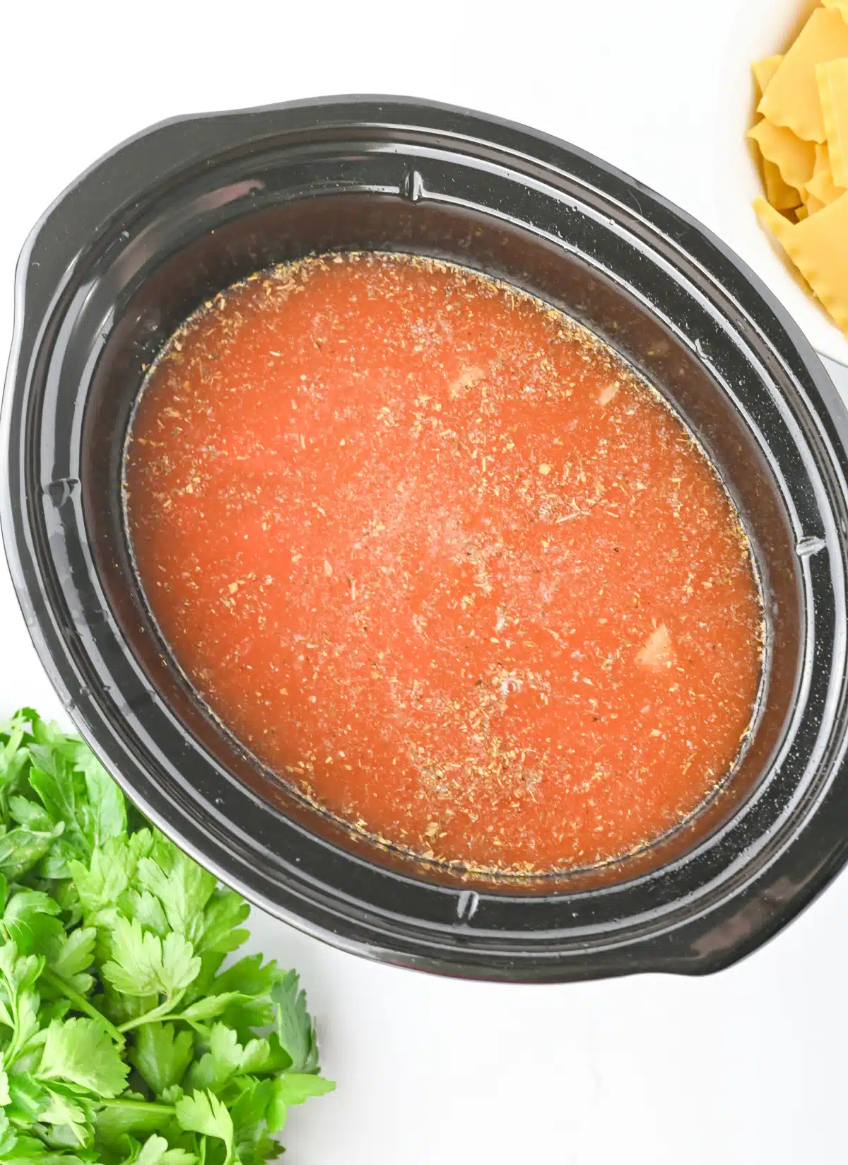 broth and marinara sauce in the slow cooker