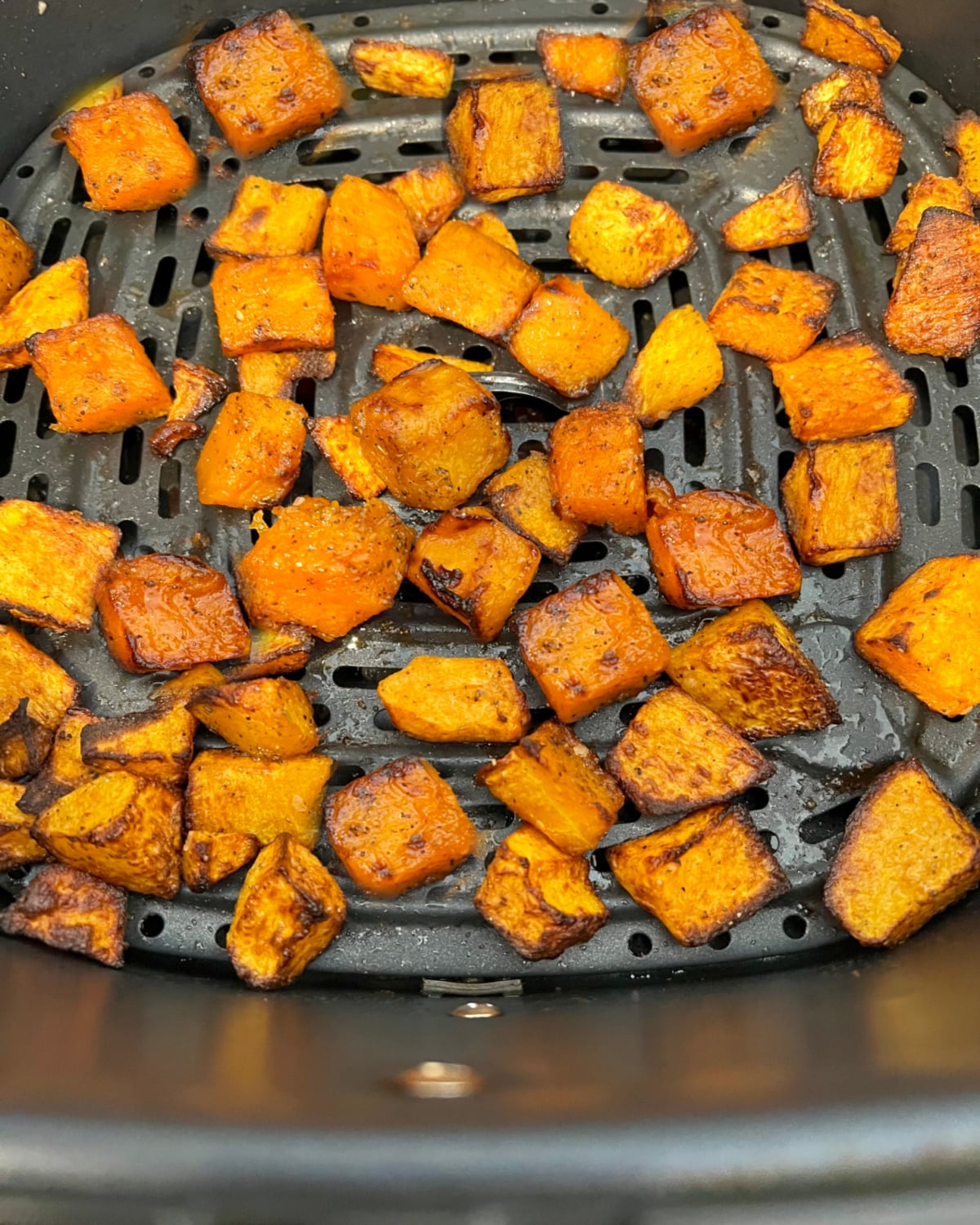 cooked butternut squash in the air fryer basket