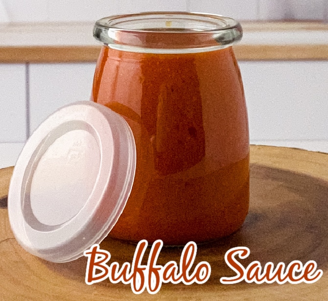 buffalo sauce in a tall glass jar with a lid on the side 