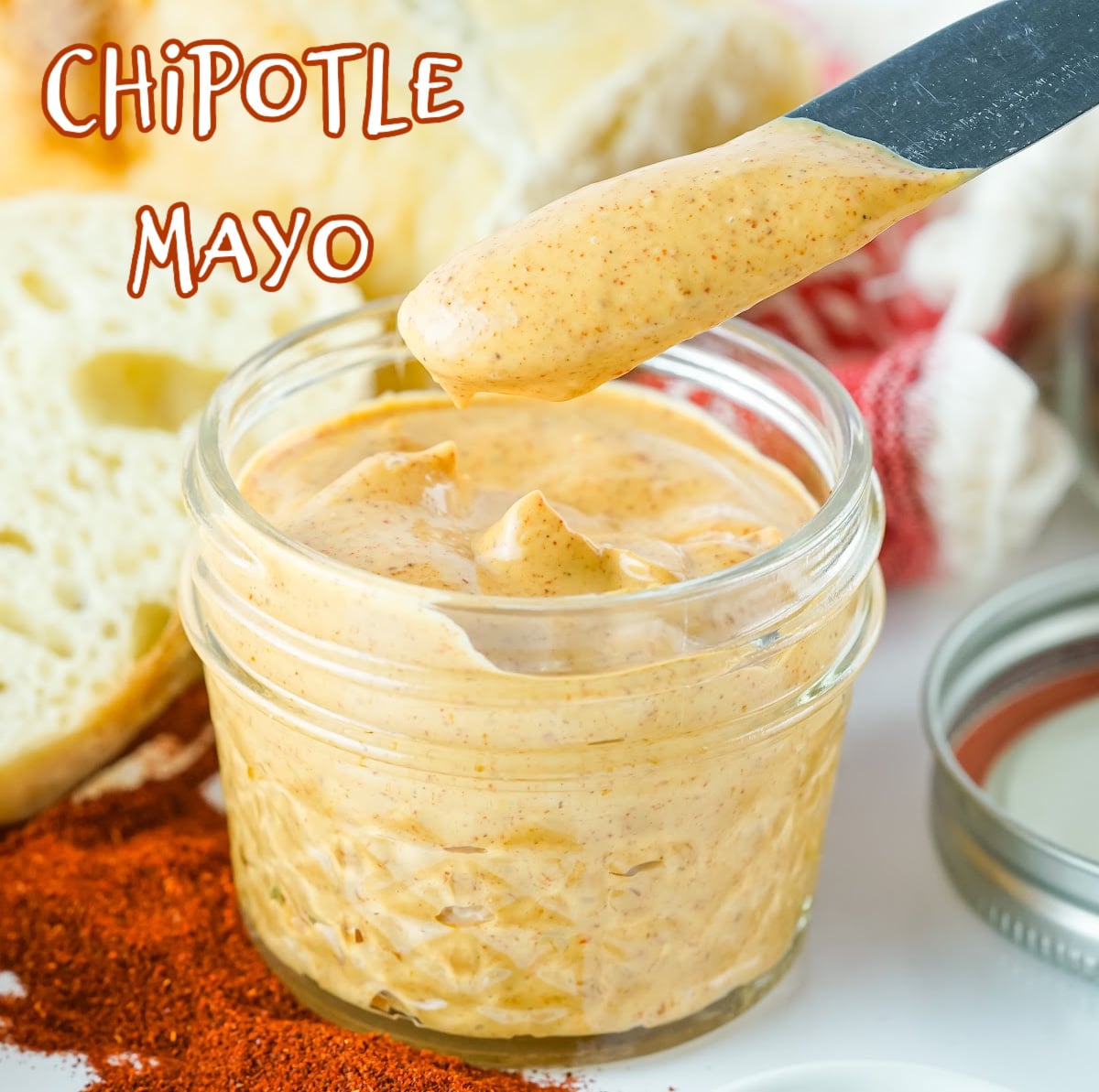 homemade chipotle mayo in a jar with a knife