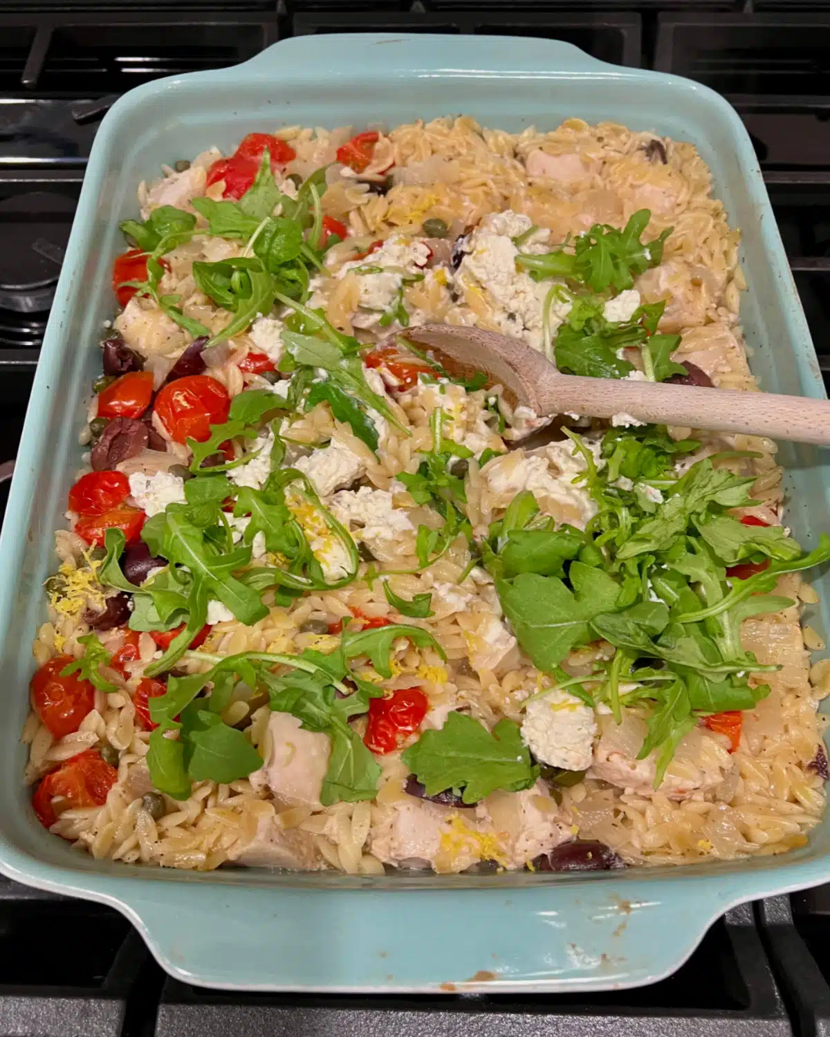stirring in arugula, tomatoes,and cheese
