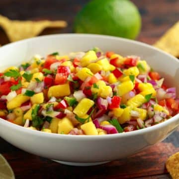 bowl of homemade pineapple salsa with tortilla cjips in background