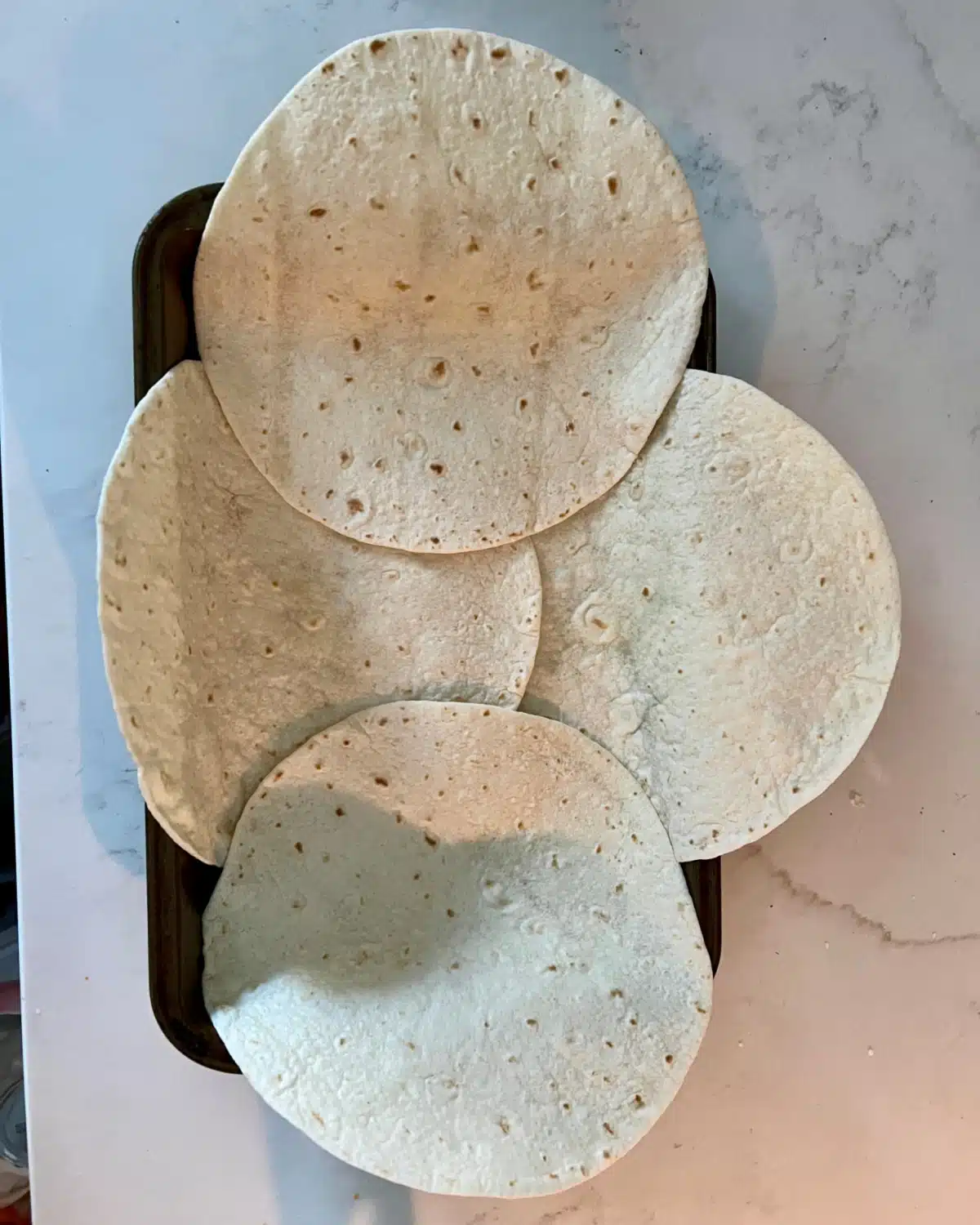 arranging tortillas in baking pan