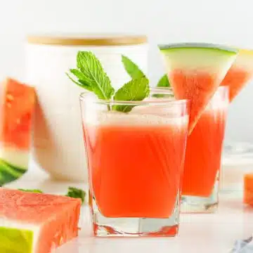 two glasses of watermelon water with mint and watermelon garnishes