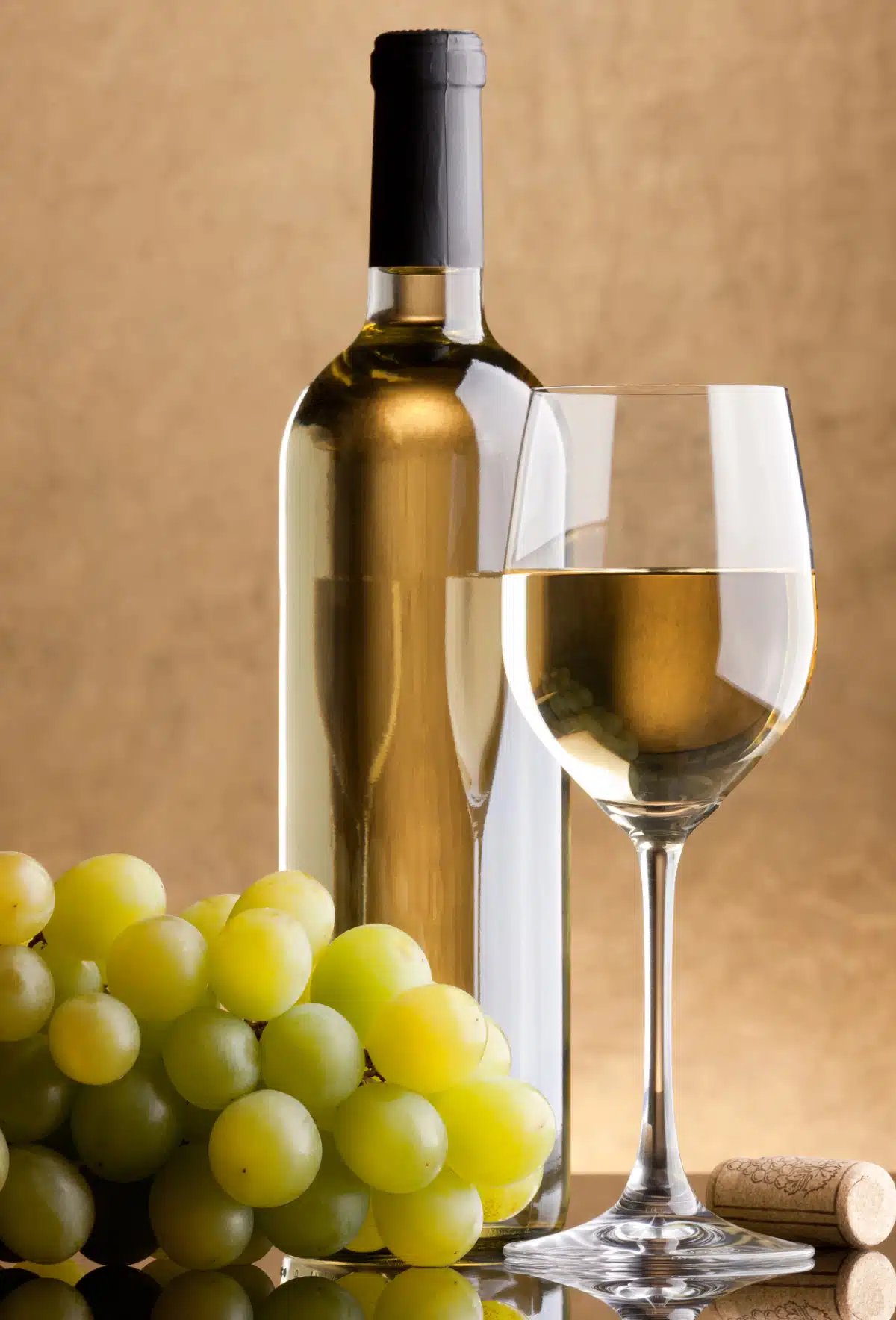 bottle and glass of white wine with green grpaes