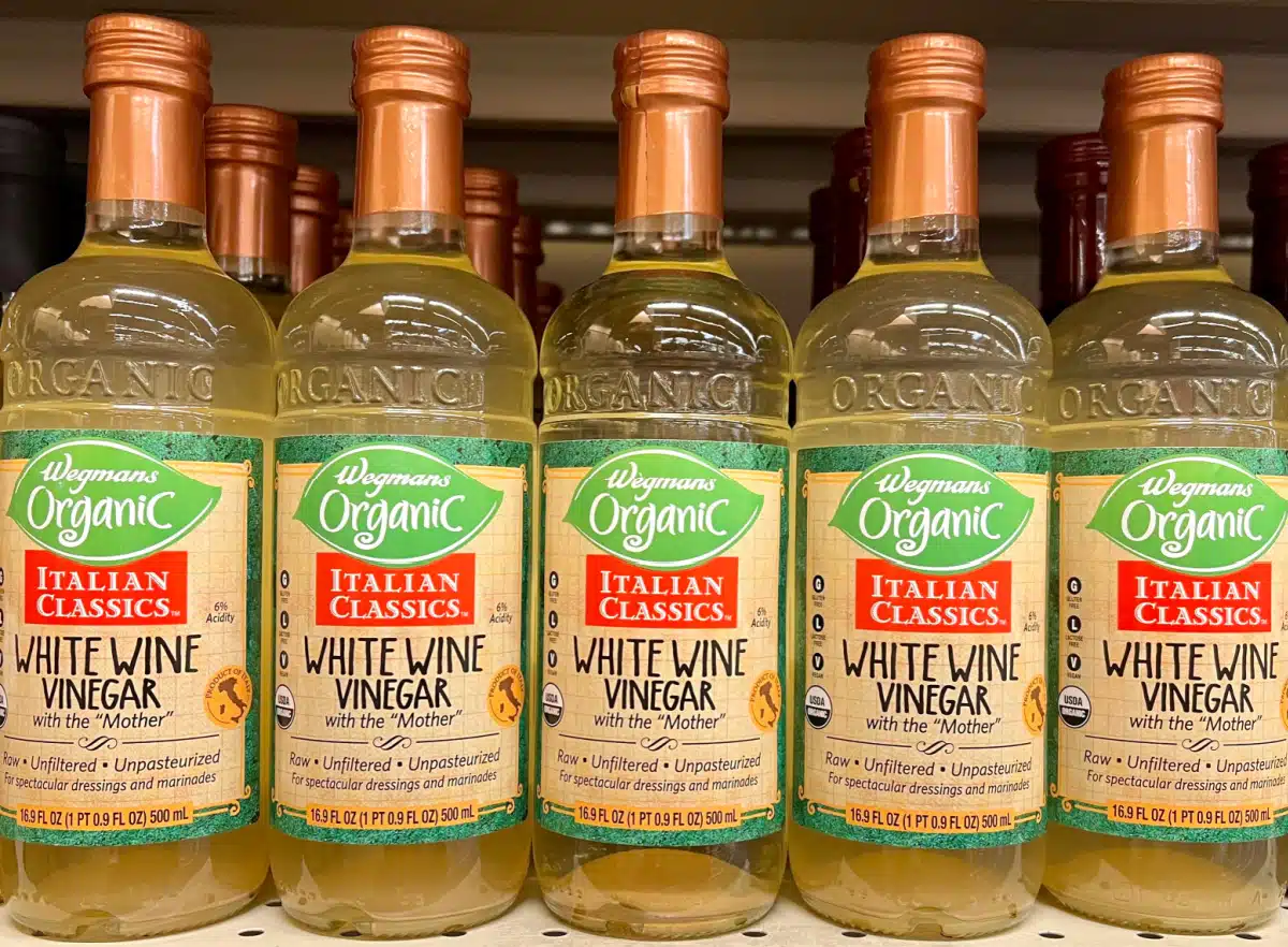 several bottles of white wine vinegar on a shelf