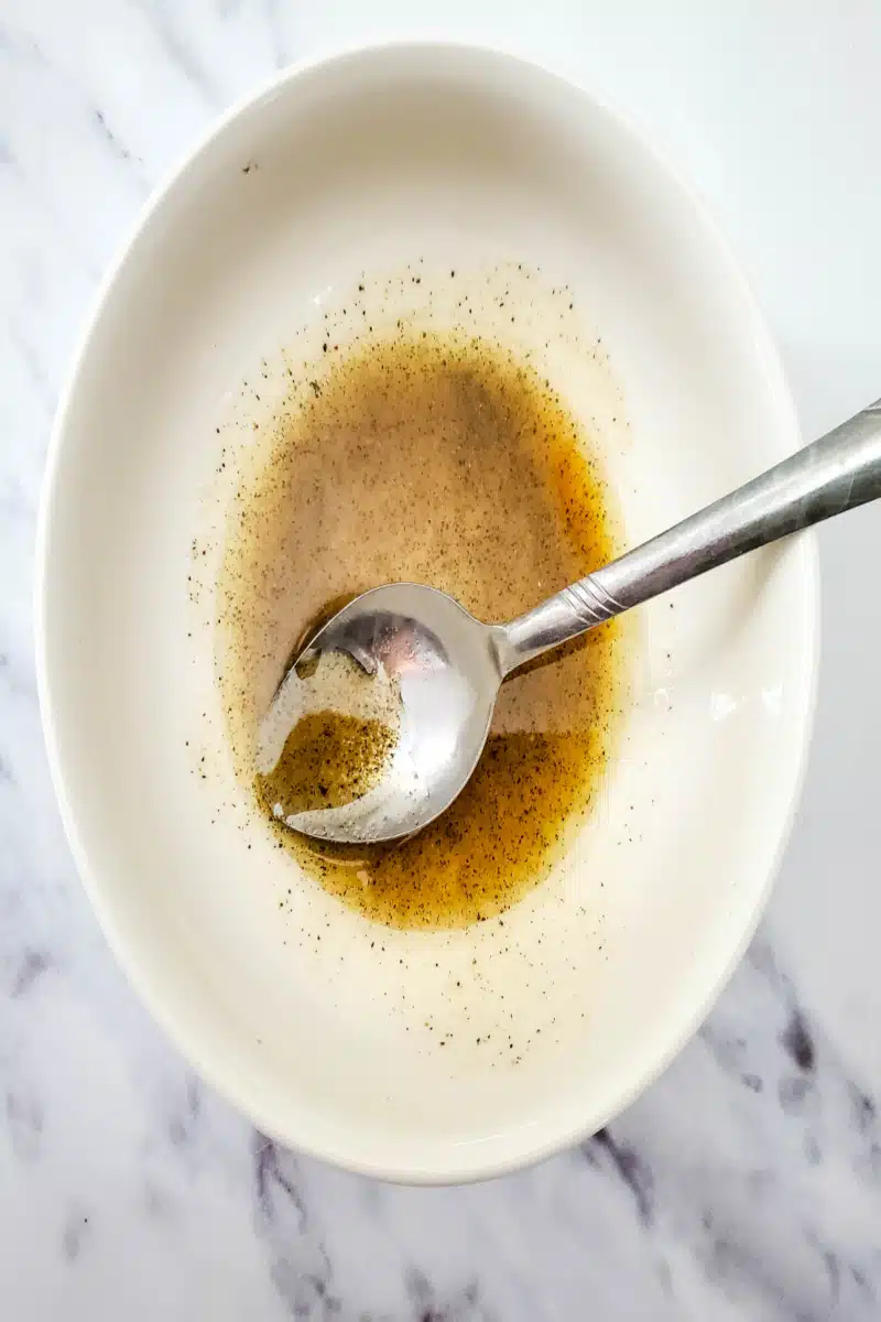 combining olive oil, vinegar and seasonings in a bowl
