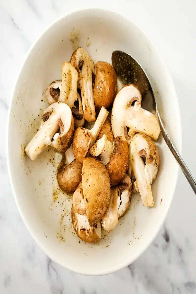 tossing mushrooms in olive oil and seasonings