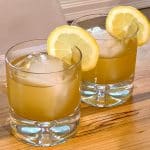 two glasses of Bee's knees cocktails with lemon garnishes