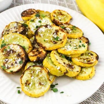 air fried summer squash on a white dish with fresh squash