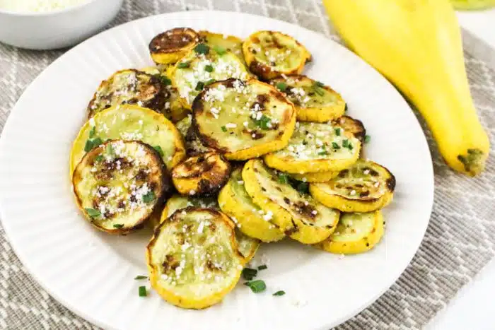 air fried summer squash on a white dish with fresh squash