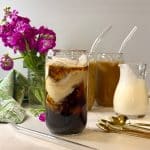 two glasses of iced coffee latte with purple flowers