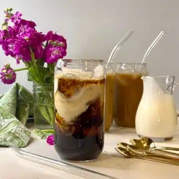 two glasses of iced coffee latte with purple flowers