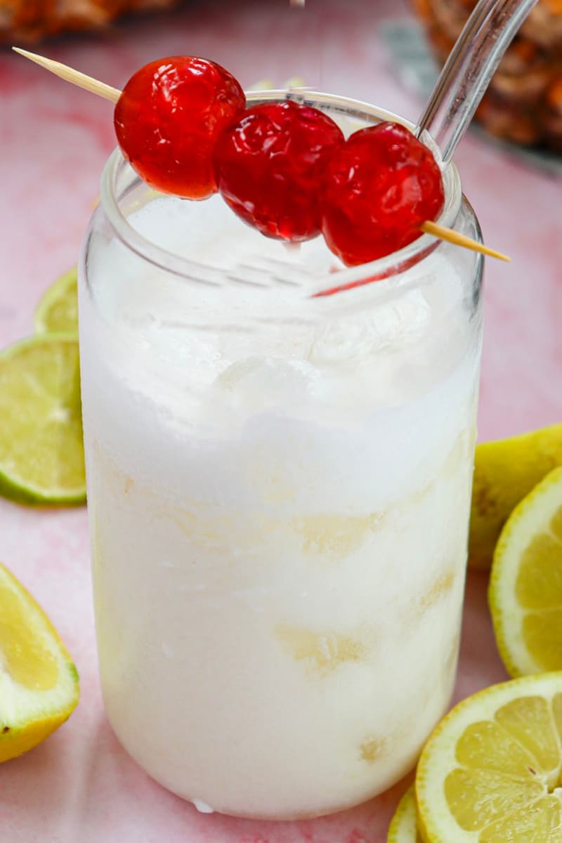 garnishing pina colada mocktail with cherries