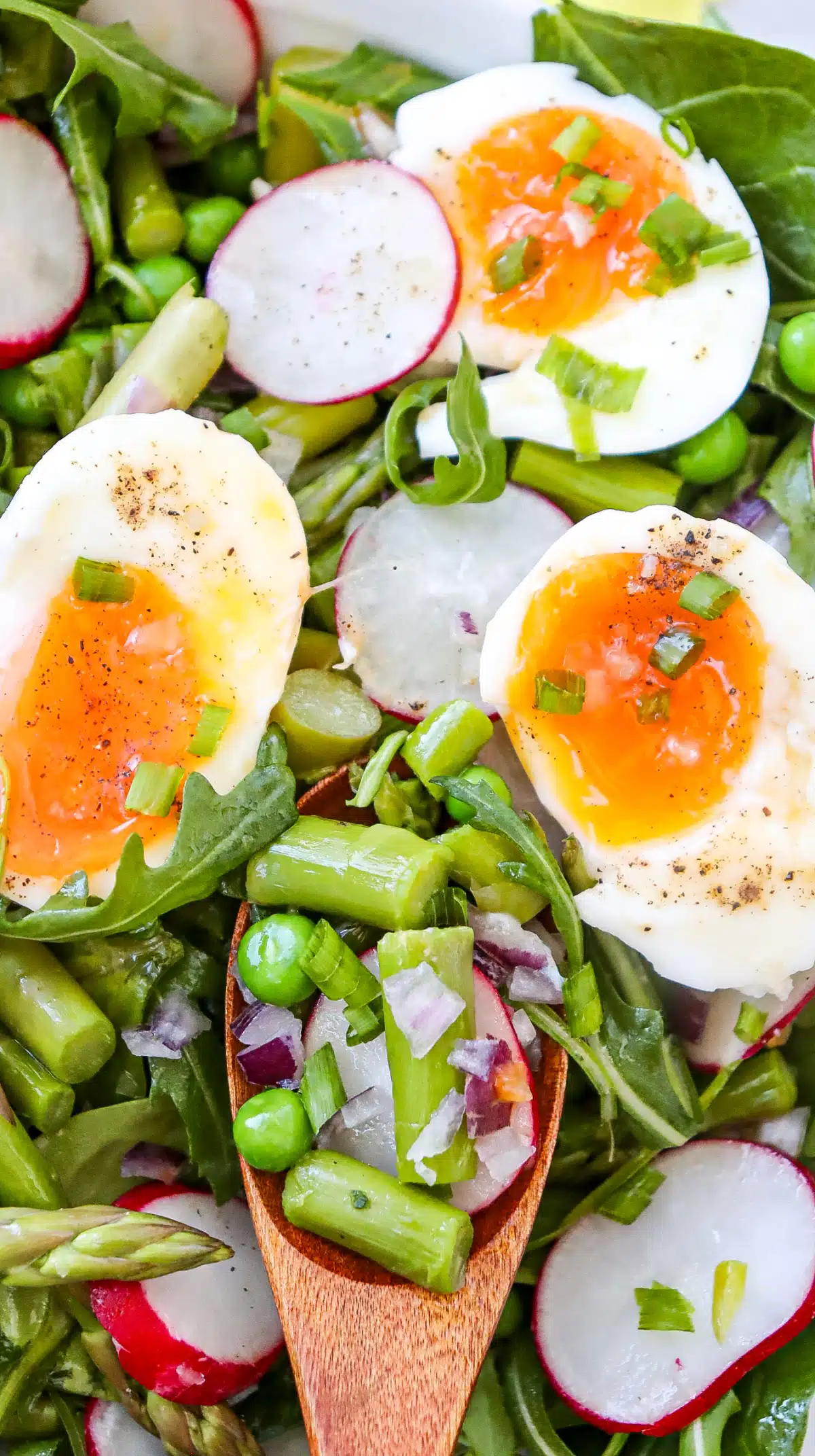 arugula spinach salad on a wooden spoon