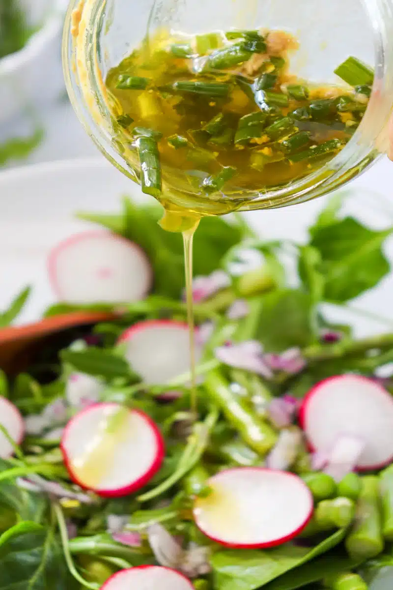 drizzling vinaigrette over the arugula spinach salad