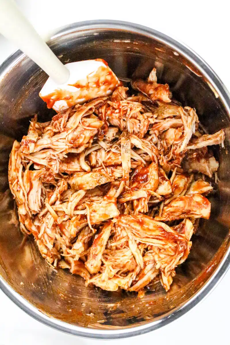 combining shredded chicken with barbecue sauce and BBQ seasoning