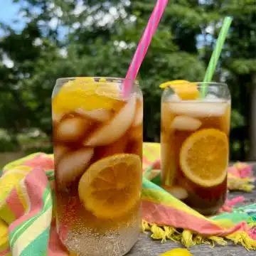 two glasses of espresso tonic with straws and colorful napkin