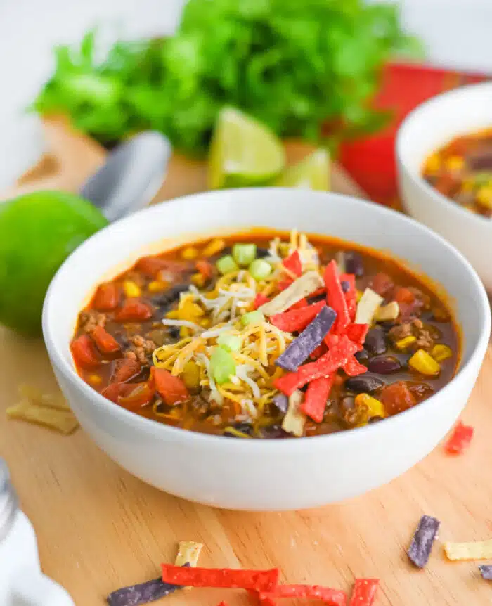 taco soup in a white bowl with a bunch of cilantro