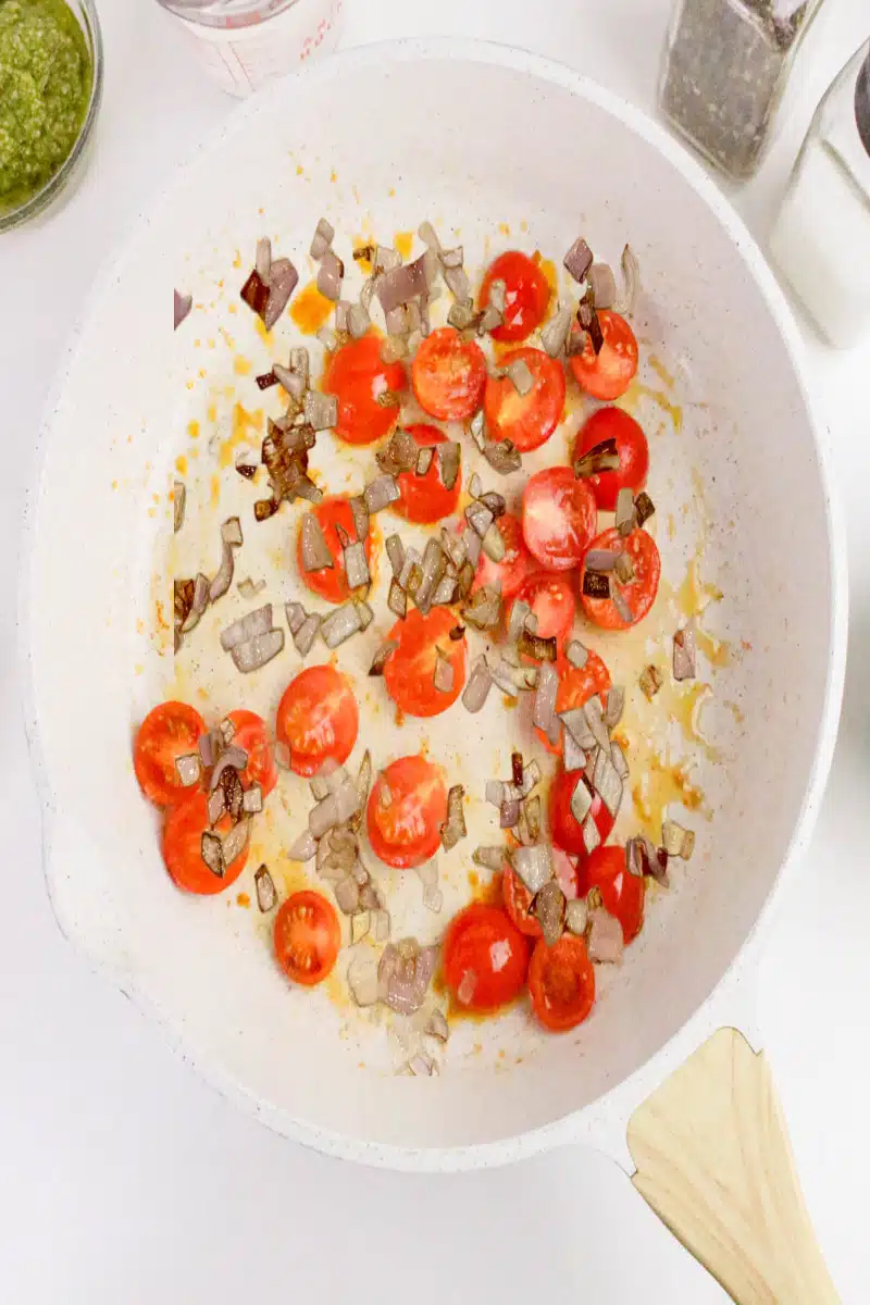 tomatoes and shallots cooking in a skillet