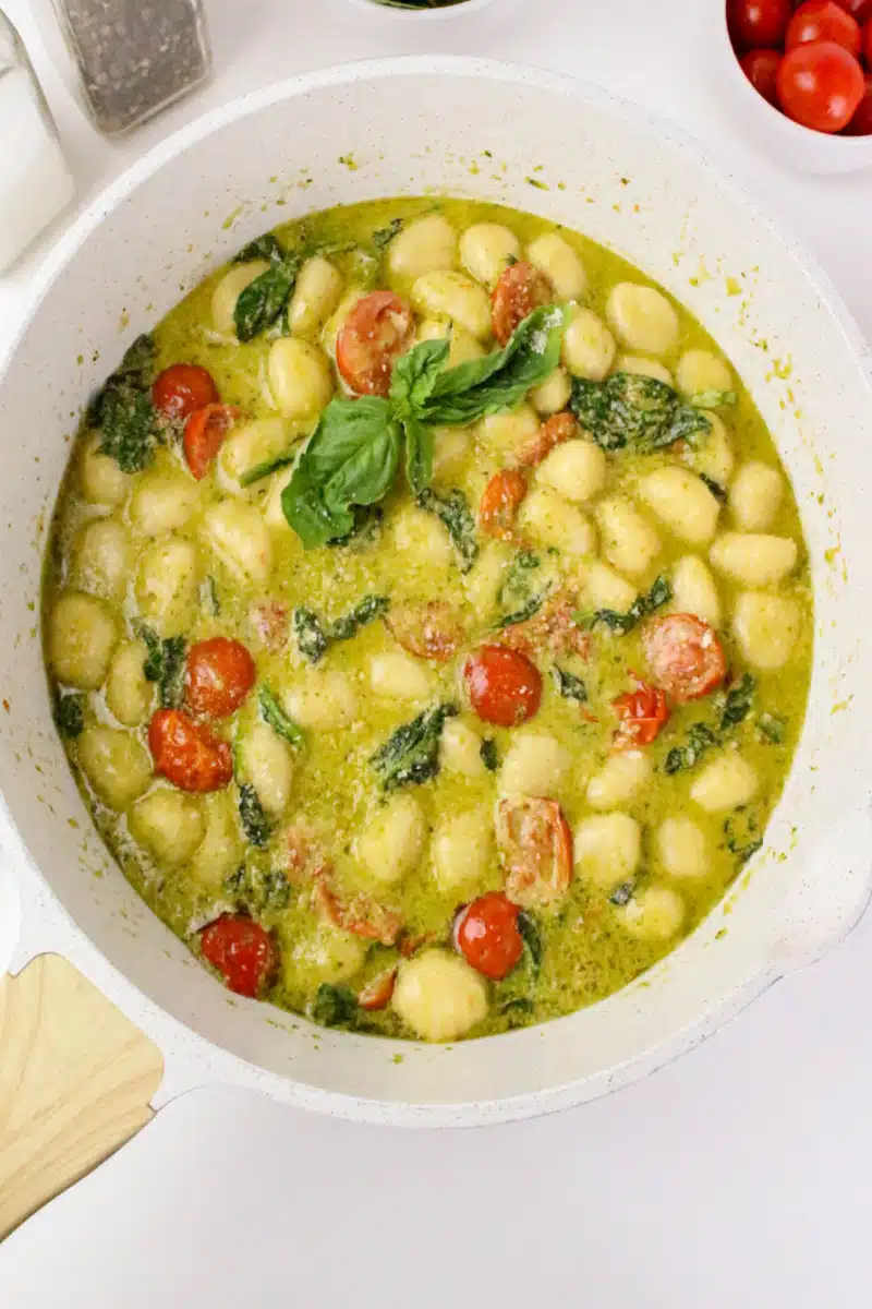 simmering gnocchi pasta in pesto cream sauce