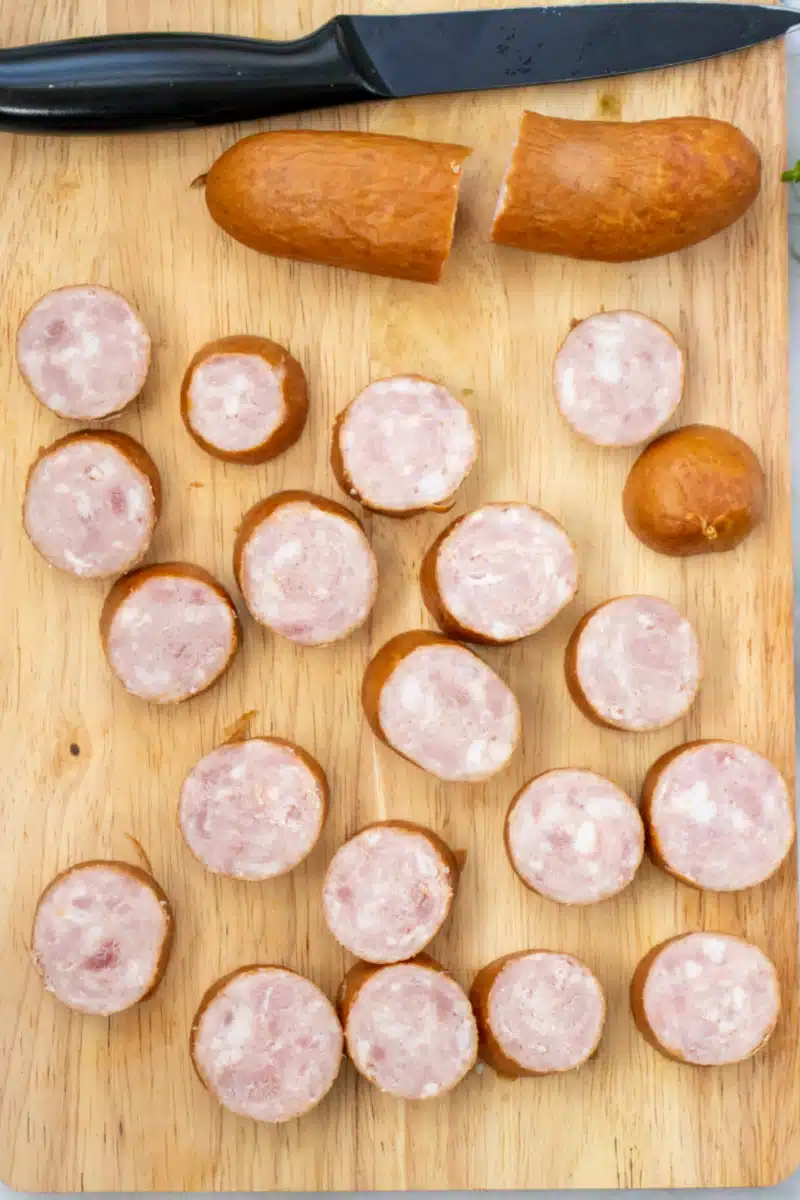slicing kielbasa on a wooden cutting board