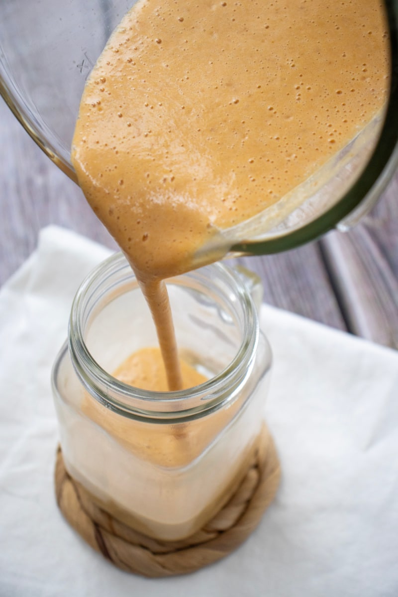 pouring protein shake from the blender into a glass