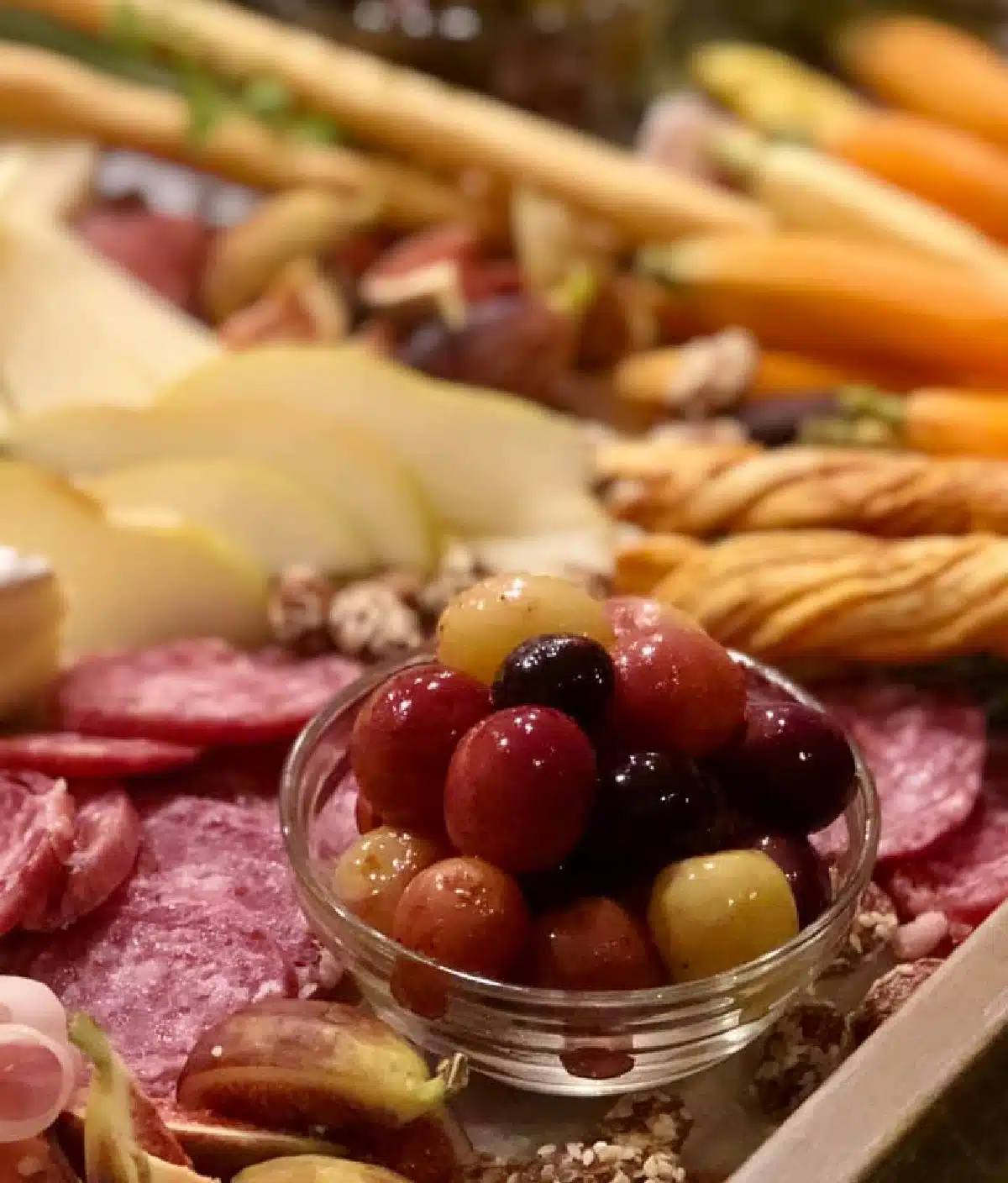 bowl of roasted grapes on a charcuterie board