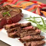 sliced ribeye steak with fresh rosemary garnish