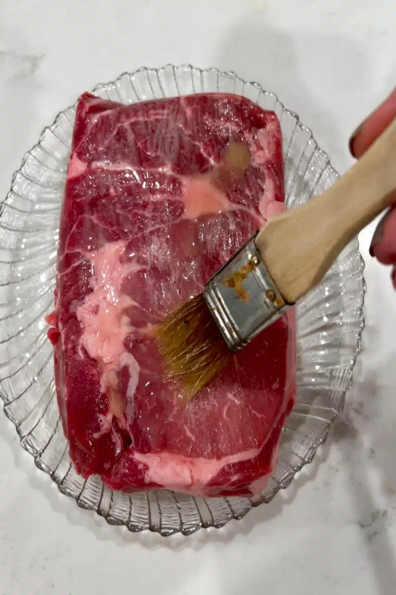 brushing steak with melted butter before cooking