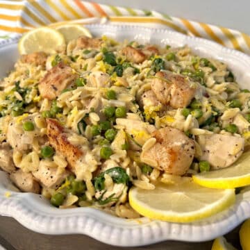 Lemon Chicken Orzo Pasta in a white serving dish with lemon slices garnish