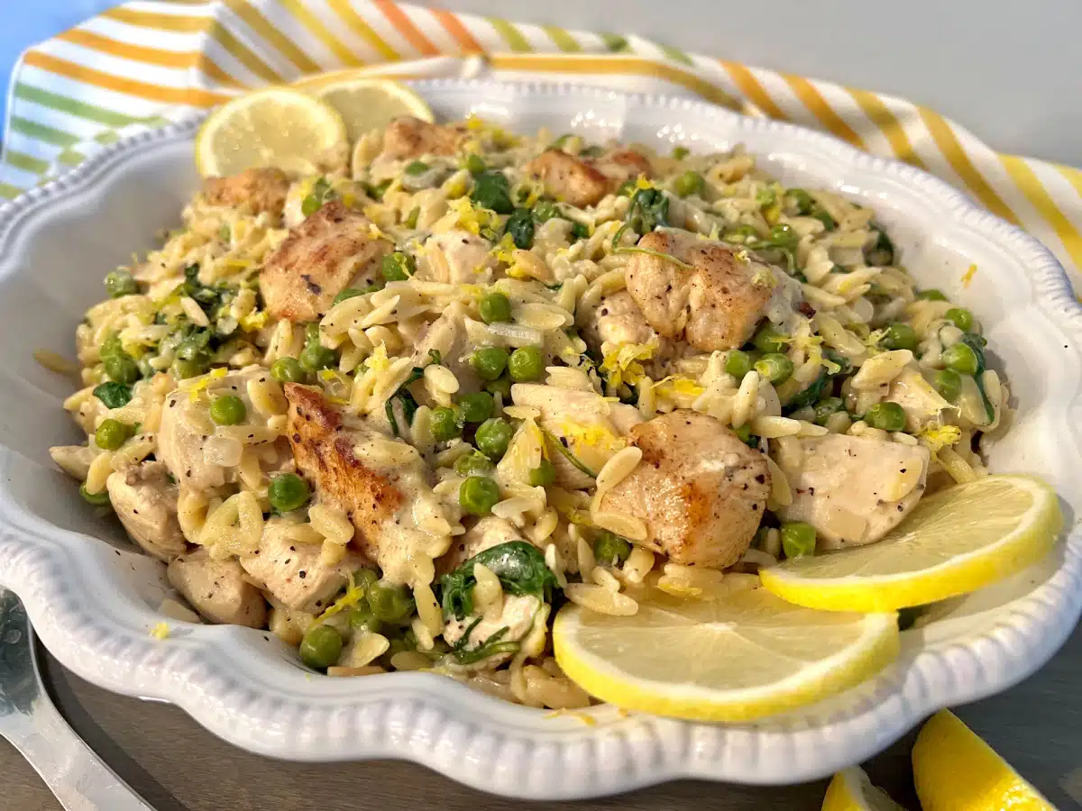 Lemon Chicken Orzo Pasta in a white serving dish with lemon slices garnish