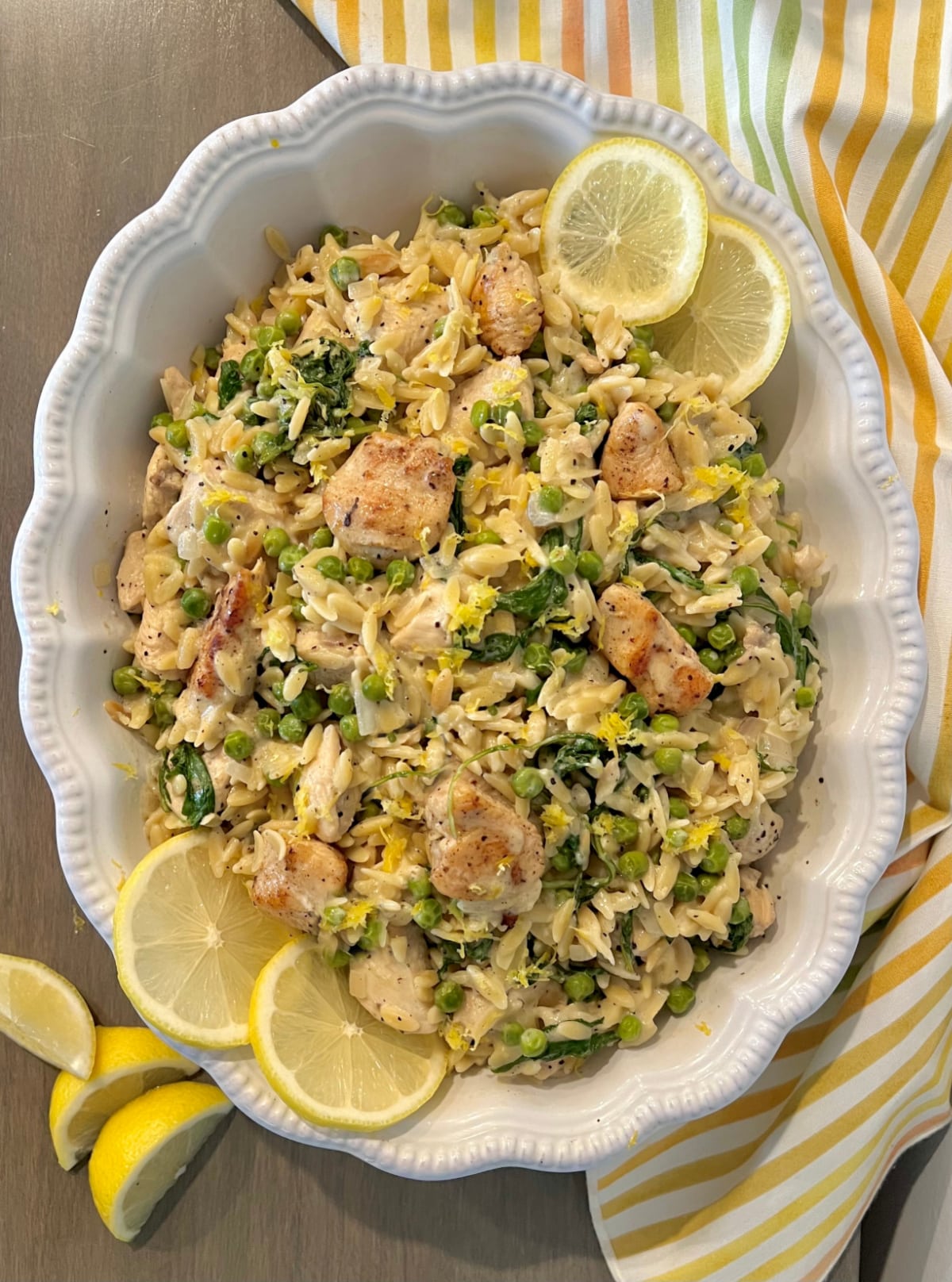 overhead of lemon chicken with pasta in a white serving dish