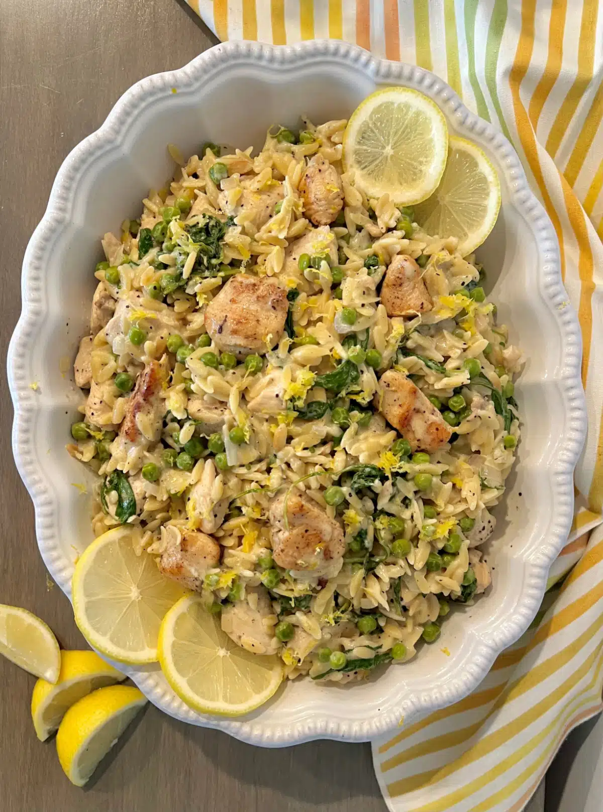 overhead of lemon chicken with pasta in a white serving dish
