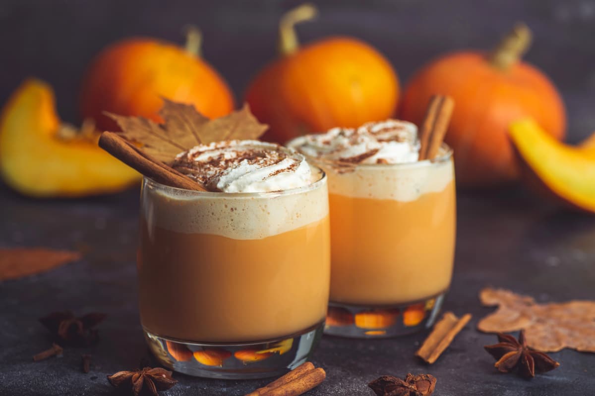 two glasses with pumpkin latte and cream
