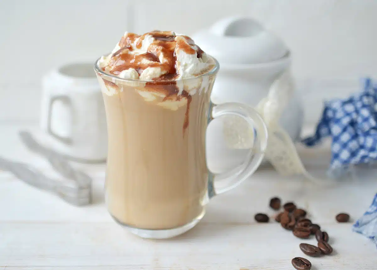 caramel macchiato latte in a glas mug with whipped cream