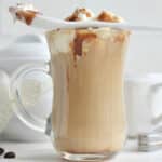 caramel macchiato latte with whipped cream and a spoon
