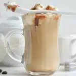 caramel macchiato latte with whipped cream and a spoon