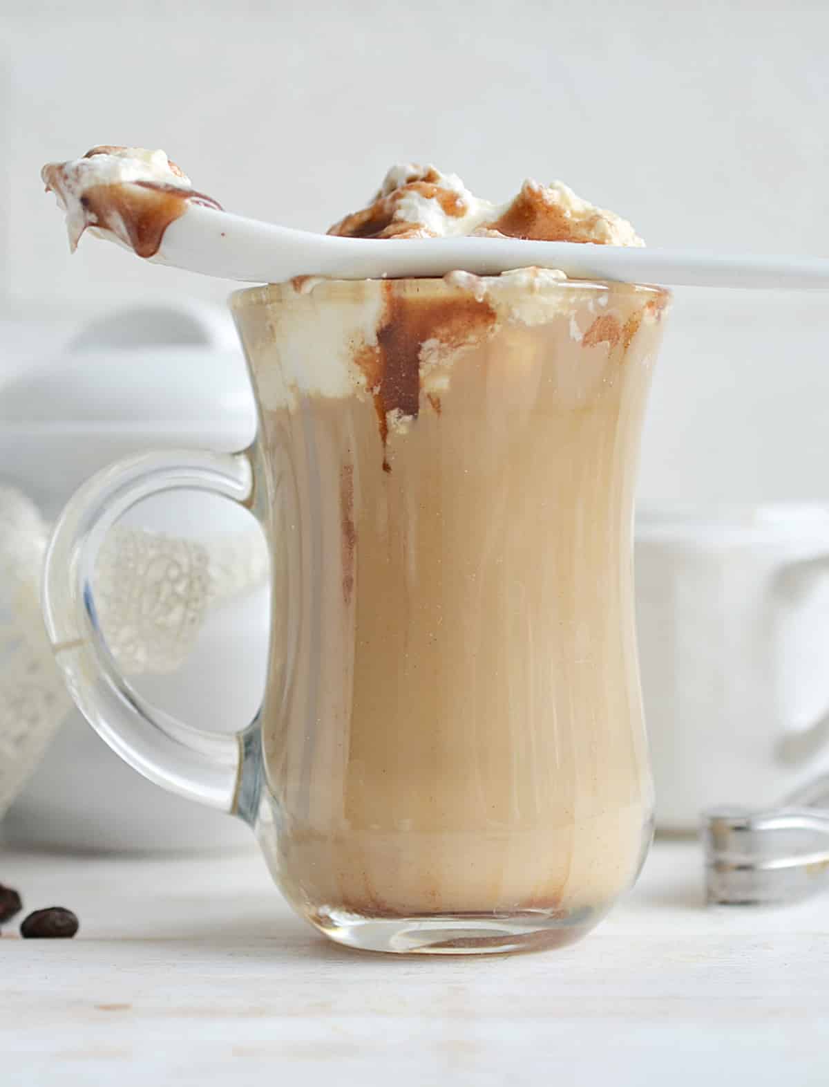 caramel macchiato latte with whipped cream and a spoon