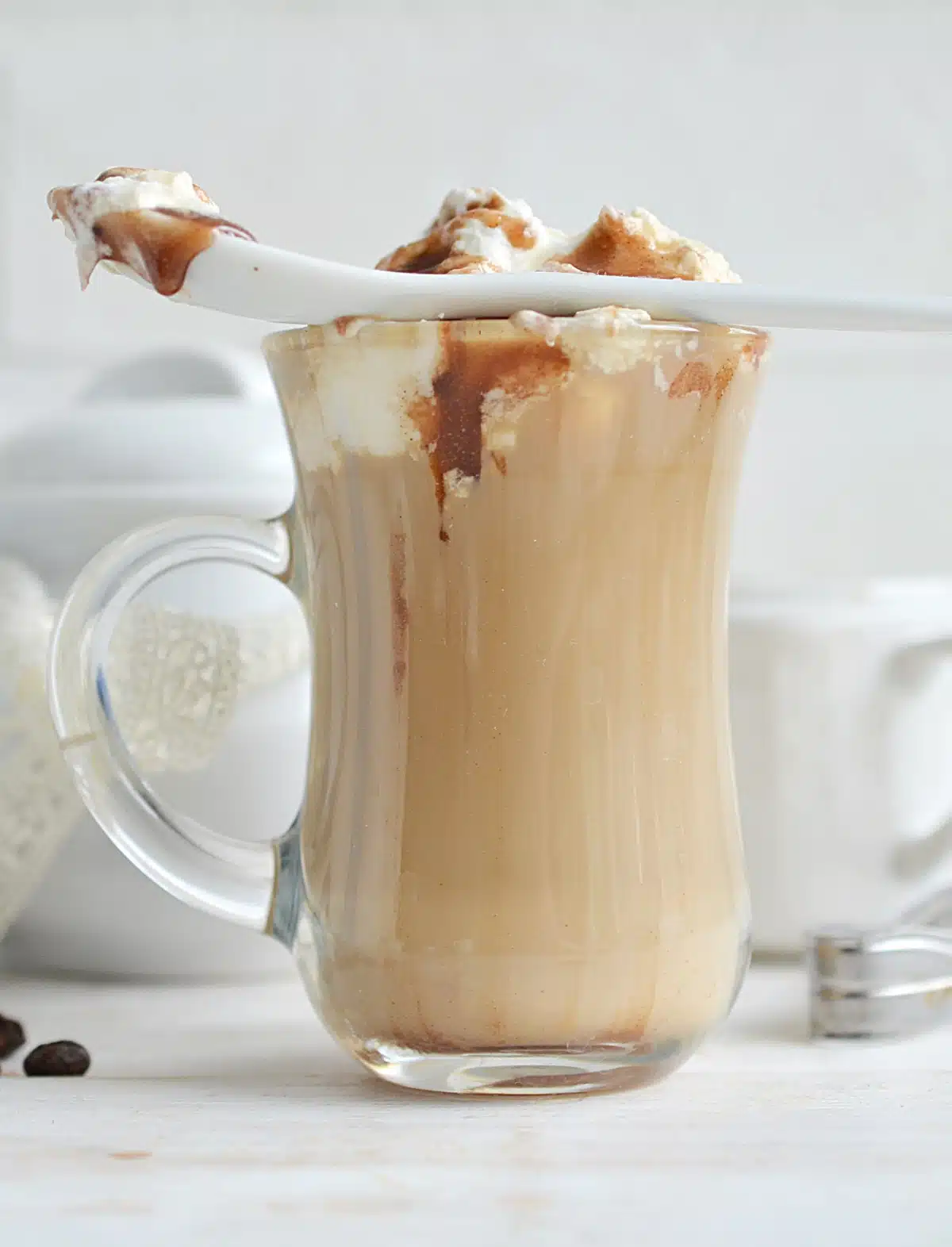 caramel macchiato latte with whipped cream and a spoon