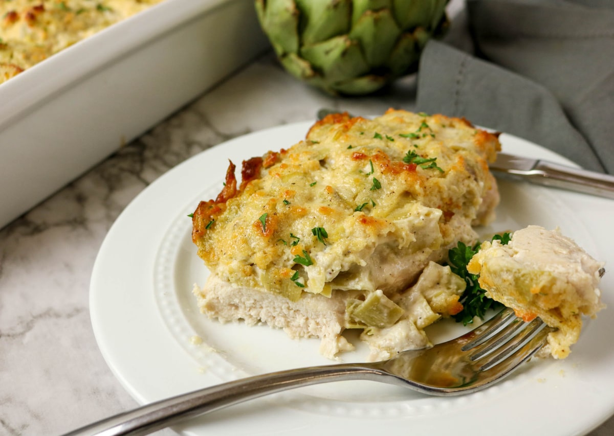 serving of chicken and artichokes in a dish with a fork