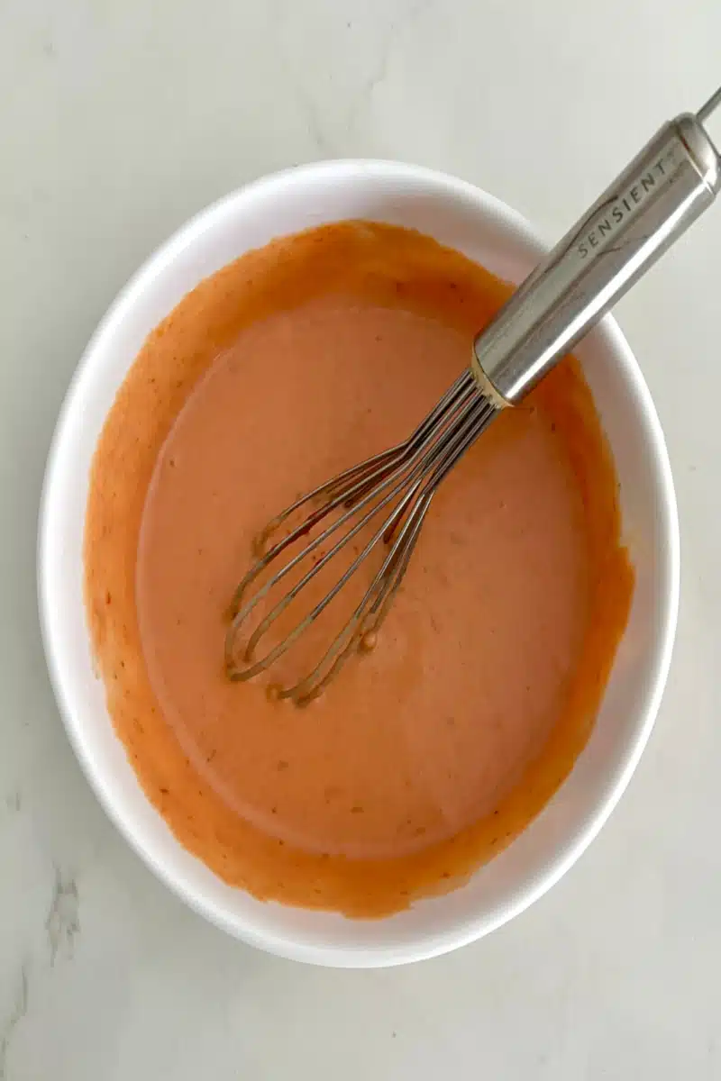 whisking bang bang sauce in a mixing bowl