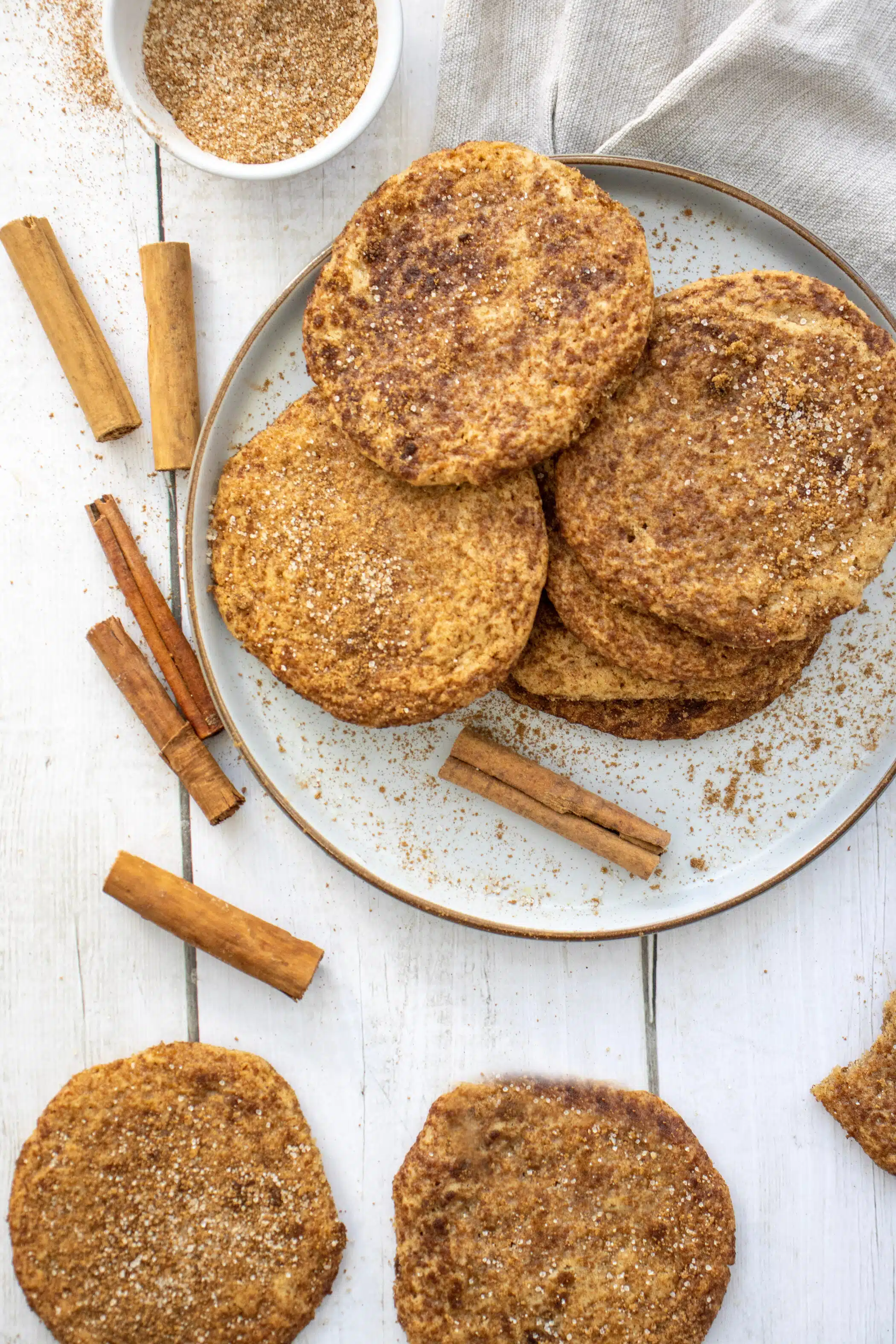 overhead of brown sugar cookies on a plate with cinnamon sticks