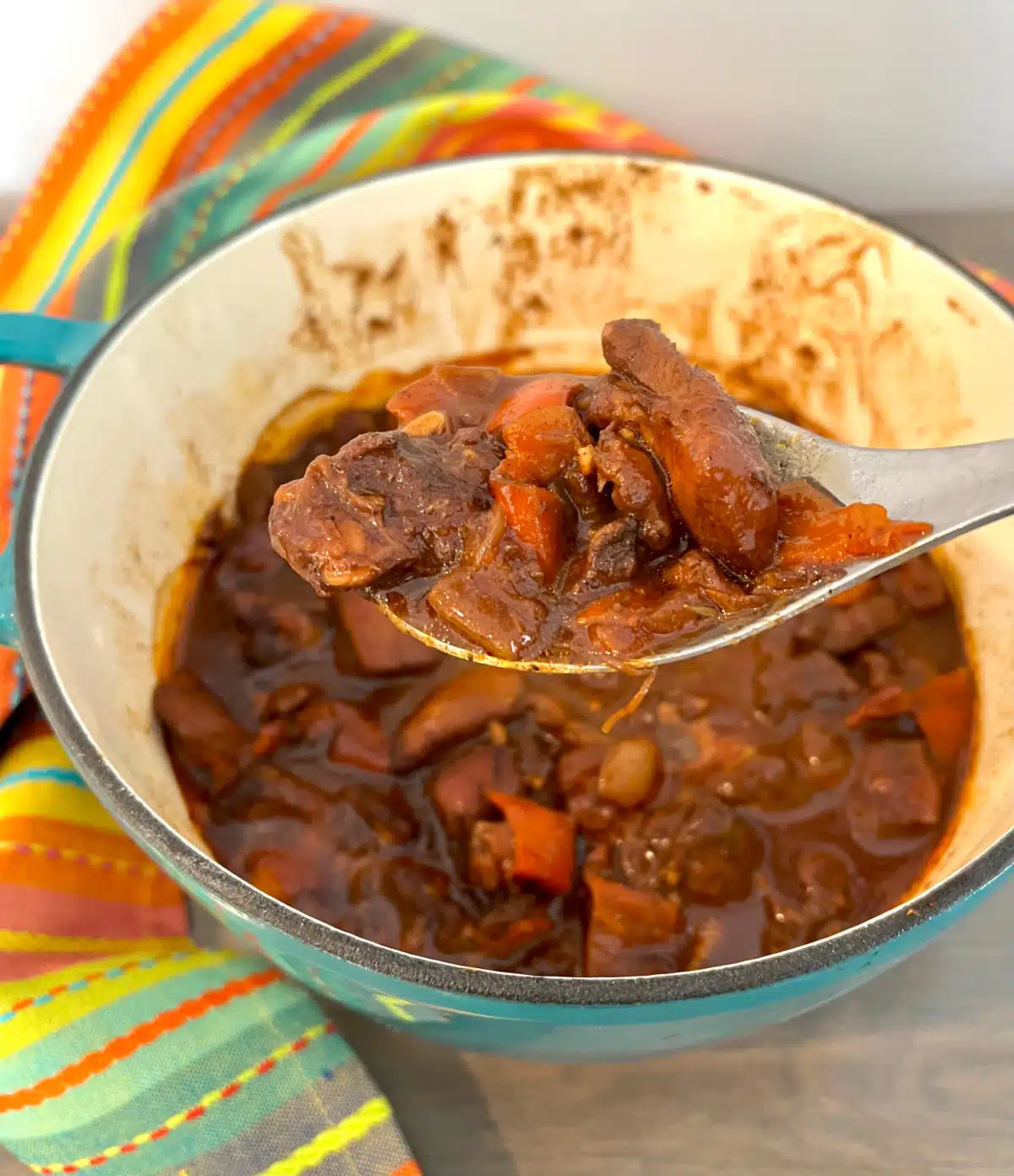 pot of browned chicken stew with a spoonful