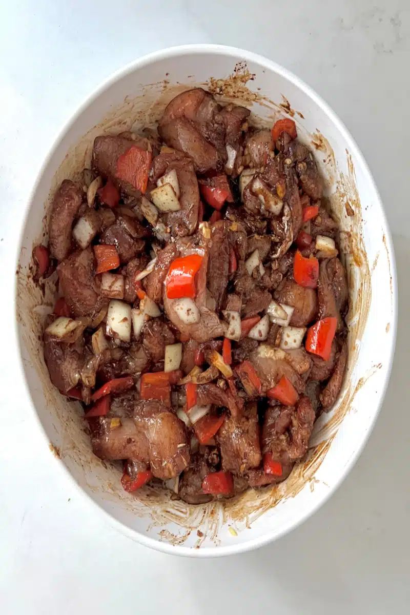 tossing ingredients for Browned Chicken Stew with seasonings