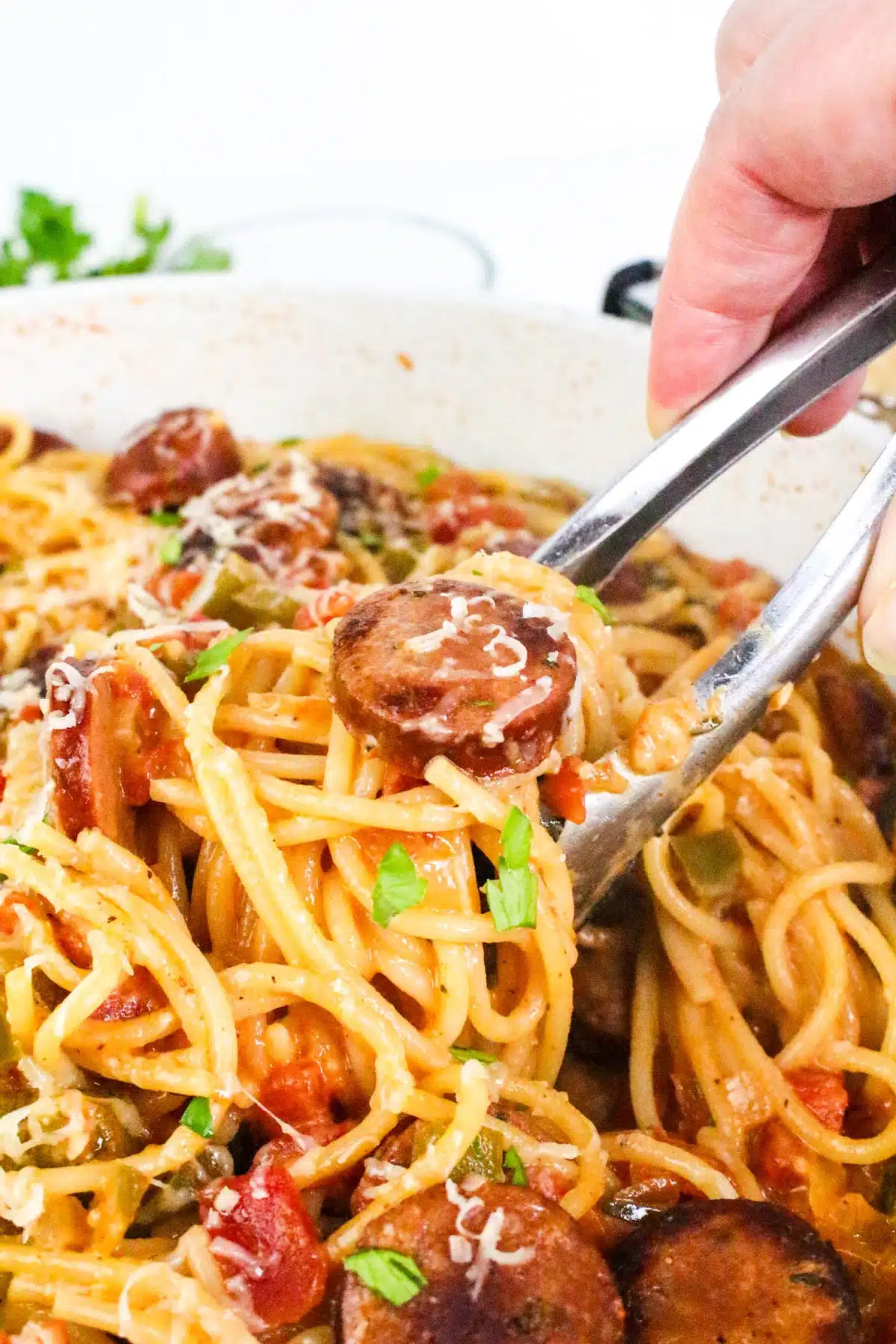 serving Cajun spaghetti with tongs