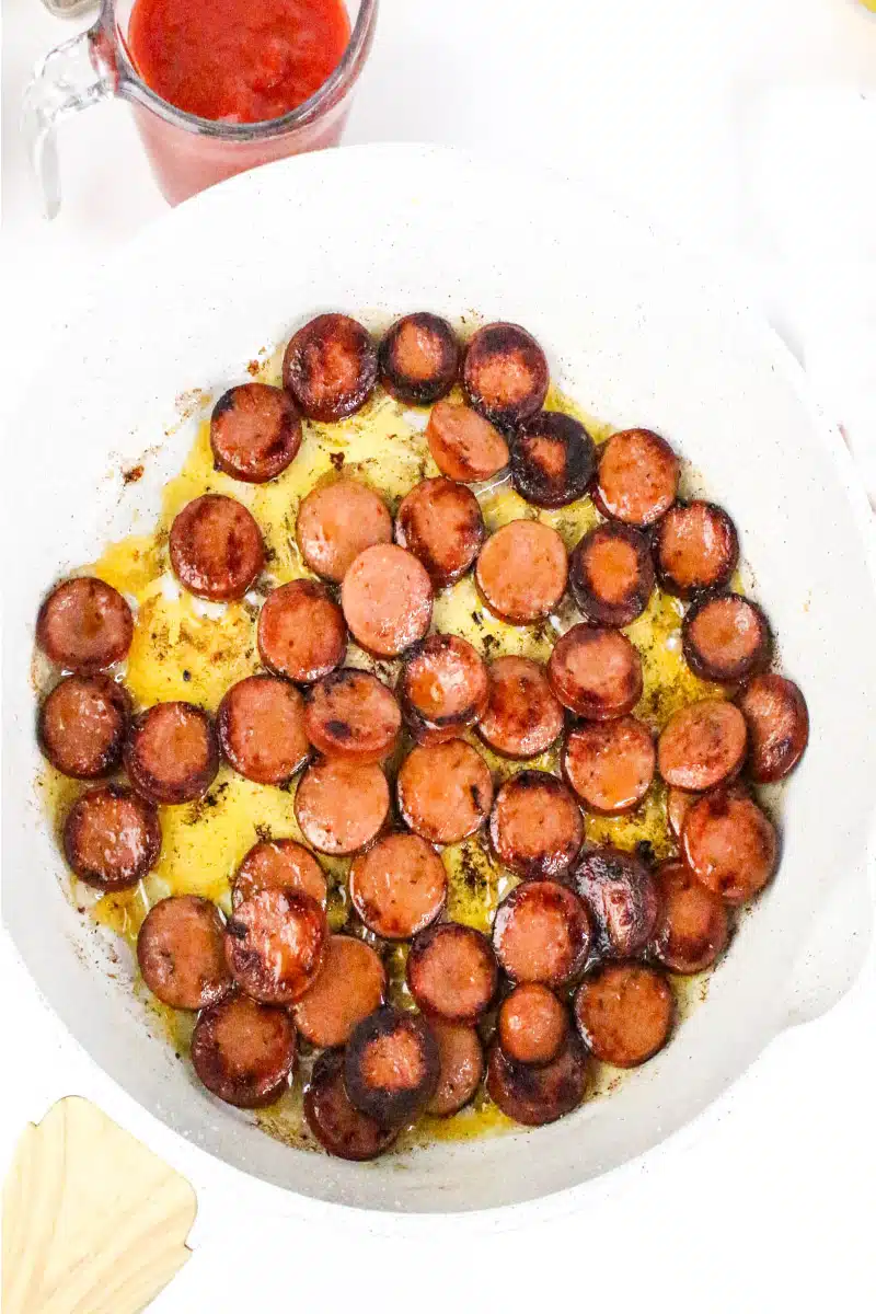 cooking Cajun sausage in a large skillet