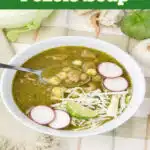 bowl of pork pozole soup with toppings and a spoon and text overlay