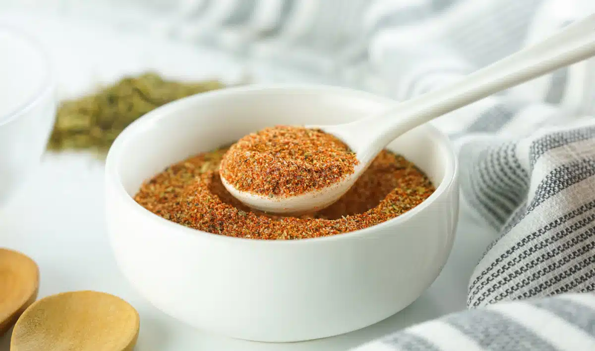 Cajun seasoning in a white bowl with a spoon